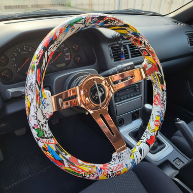 A steering wheel cover featuring a colorful comic book and graffiti print, wrapped around a bronze-colored spoke steering wheel, 